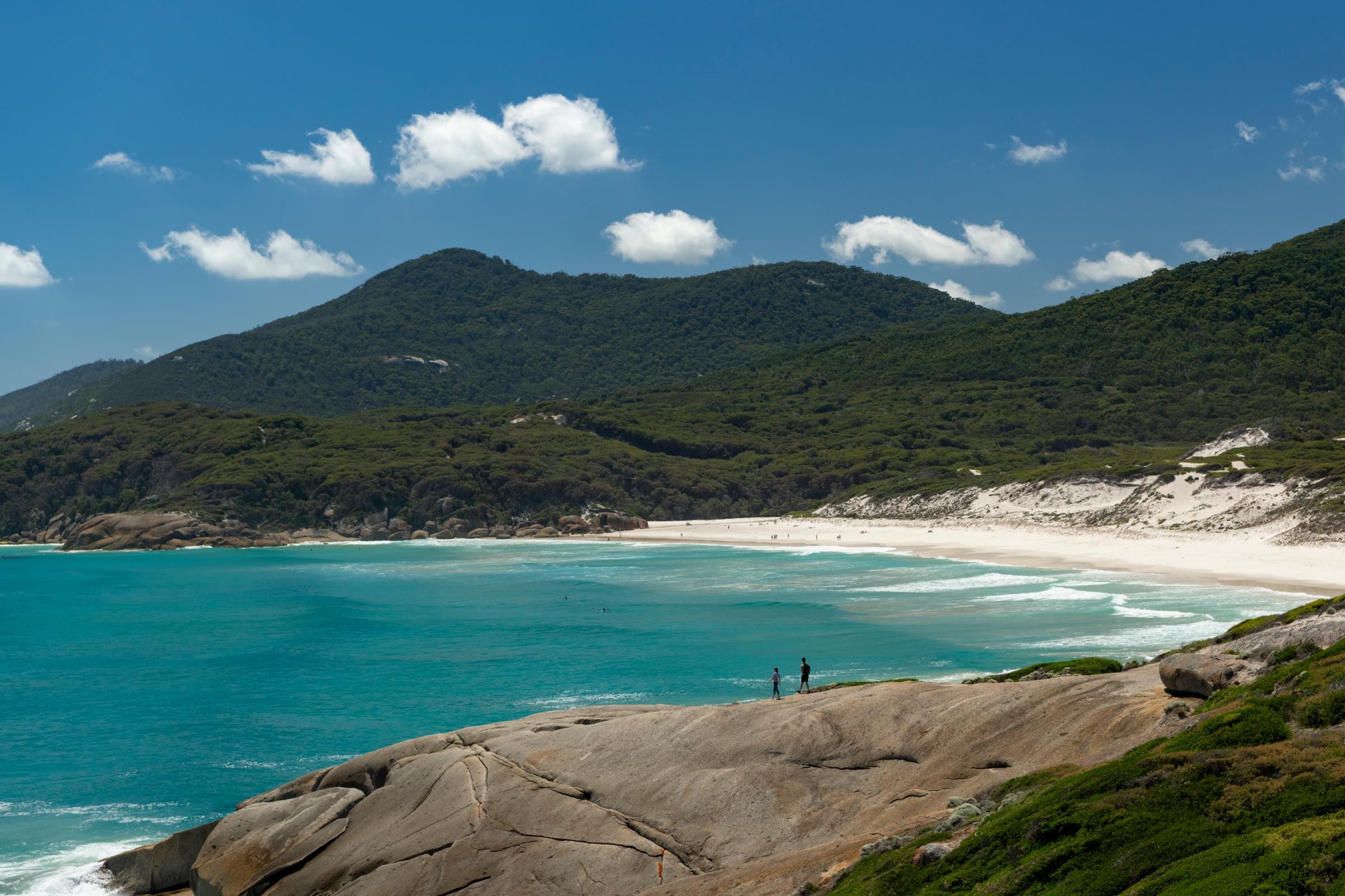 These iconic orange-hued boulders create a striking contrast against the white sand, making this beach a photographer's favorite.